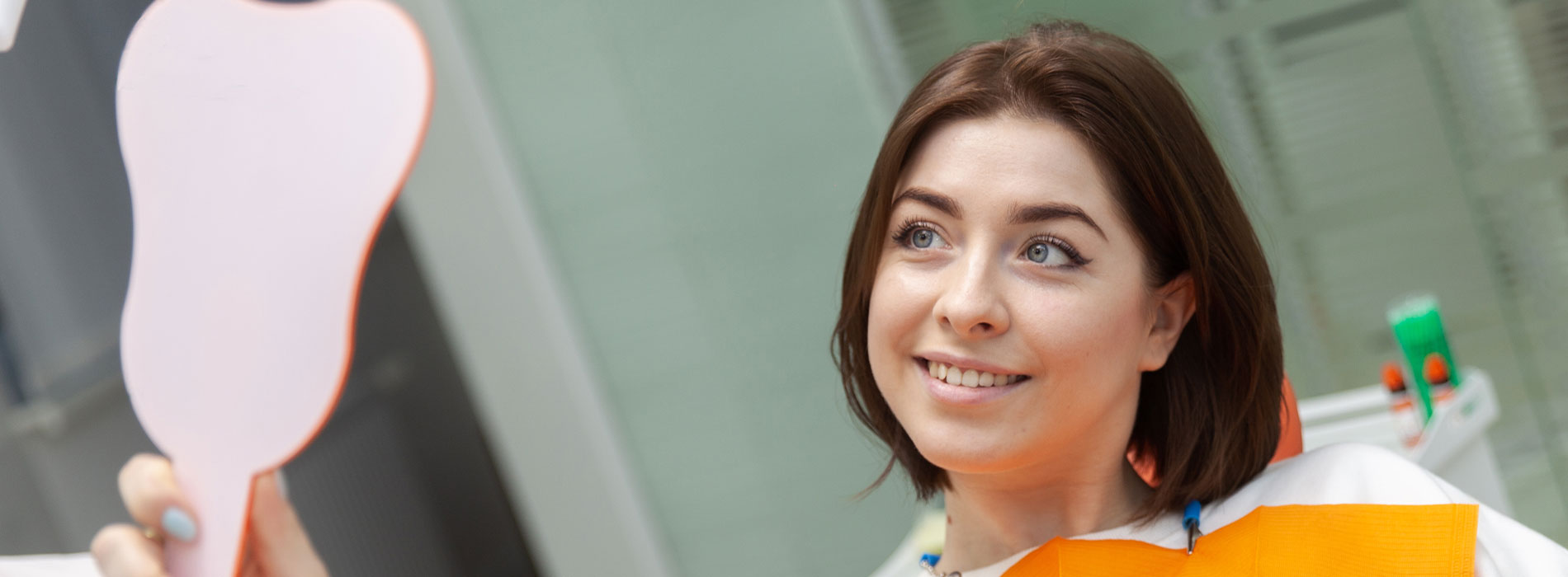 A woman holding a large pink apple in her hand.