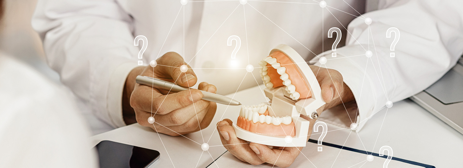 An image of a dental professional holding a model set of teeth, with an overlay of digital icons and numbers suggesting a focus on dental implants or procedures.