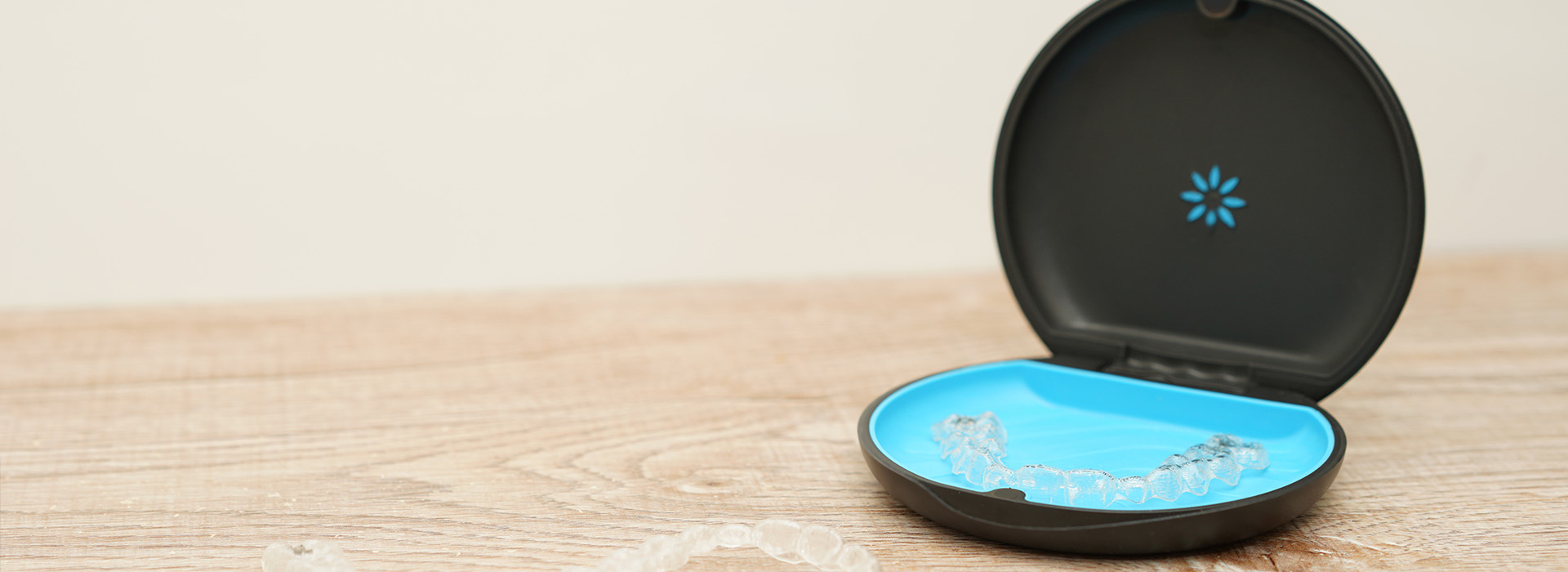 The image shows a smartphone charging station with a blue circular base and a small, round device on top of it.