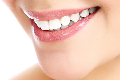 The image features a close-up of a person's face, focusing on their teeth and lips.