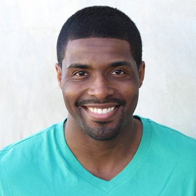 An elderly couple seated closely together, smiling and posing for a photograph.